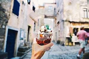 Tourist holds Fritule on street in Croatia. Croatian homemade fr