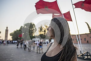 Tourist in the Jemaa el Fna square in Marrakech next to the Moroccan flag