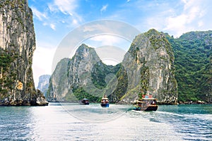 Tourist junks floating between limestone karsts and isles in Ha long Bay, Vietnam photo