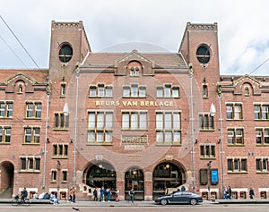 Tourist and locals passing the old trading building Beurs van Berlage on the Damrak. Named after the architect who build it.