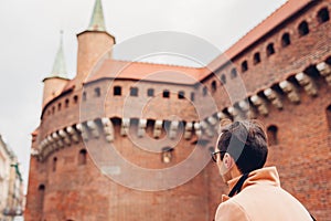 Tourist looking at Barbikan gate in Krakow city  Poland. Barbakan museum. Man enjoys sightseeing