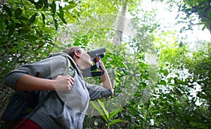 Tourist looking through binoculars exploring the wild birds in t