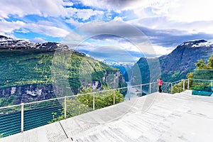 Tourist looking at Geirangerfjord from Flydasjuvet viewpoint Norway