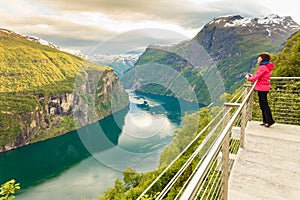 Tourist looking at Geirangerfjord from Flydasjuvet viewpoint Norway