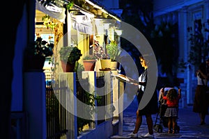 A tourist looks at the menu of a restaurant in Lefkes, Paros island