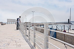 Tourist looks at the sea from the pier in Italy, Europe