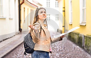 Tourist lost in the city. Confused woman holding map.
