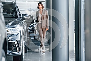 Tourist with lugagge. Woman is indoors near brand new automobile indoors photo