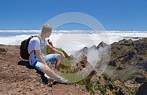 The tourist on Madeira has a rest, having got on the top located