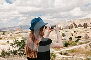A tourist makes a photo on the phone in memory of a beautiful view of the hills in Cappadocia in Turkey. Travel, tourism photo