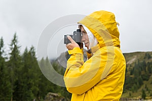 Tourist makes photos of meadows of Alpine mountain