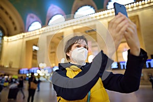 Tourist making photo of an interior of Grand Central Station New York. Mature woman is making selfie on the background of central photo