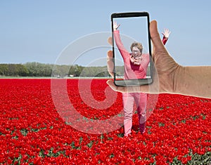 Tourist making photo of womanin tulip field