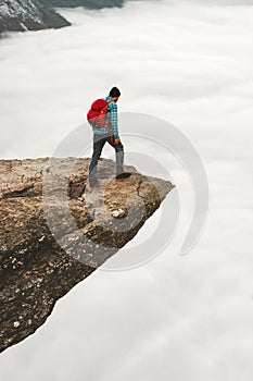 Tourist Man with backpack on Trolltunga rocky cliff