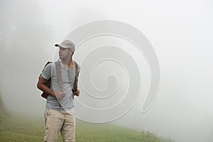 Tourist man backpacker walking alone on nature background