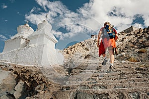 Tourist man climbs up stairs to tibetan holy place in Himalaya m