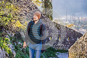 tourist man enjoying a view of Kotor Bay, Montenegro. Kotor Old Town Ladder of Kotor Fortress Hiking Trail. Aerial drone