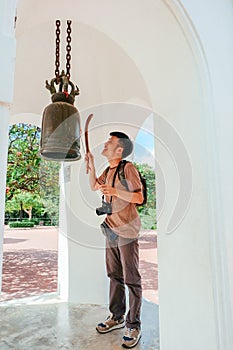 Tourist man knock the metal bell in thai temple