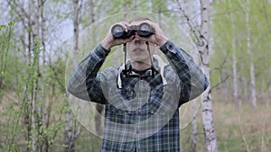 Tourist man looking through binoculars