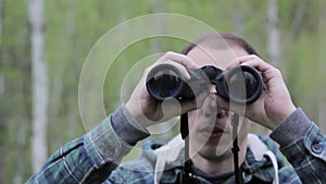 Tourist man looking through binoculars