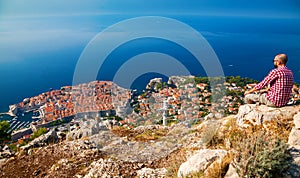 Tourist man looking down to the beautiful town of Dubrovnik