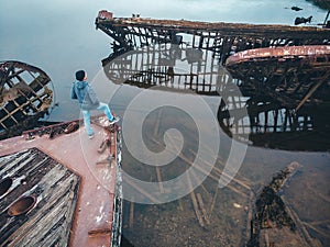 Tourist man looks at the cemetery of old wooden ships Teriberka, Murmansk region, Russia. Aerial top view