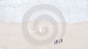 Tourist man lying on the sand and four surfboard are placed on the sandy Beach and sea wave aerial top view from drone, for