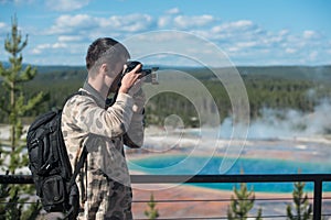 Tourist man photographer taking photos and enjoy the view of mountains in Yellowstone National Park