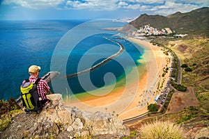 Tourist man sitting on the edge of a cliff