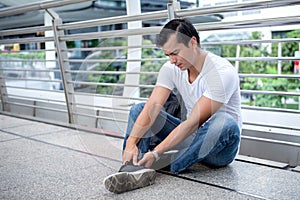 tourist man sitting on floor take off the shoes massaging feet walking a lot of foot pain after a long walk