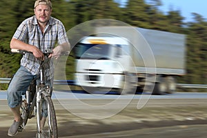 Tourist man standing on the road with a bicycle