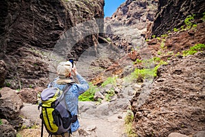 Tourist man taking a photo of the canyon Masca