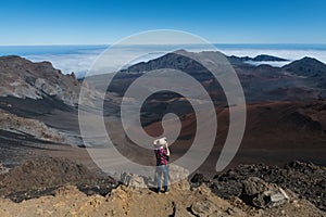 Tourist man taking photos of volcano mountain valley from the top on Big Island, Hawaii.