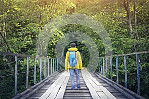 Tourist man walking across wooden bridge