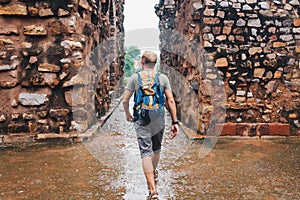 Tourist man walking by the Qutb Minar