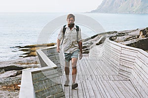 Tourist man walking on wooden bridge in Norway solo travel active healthy lifestyle