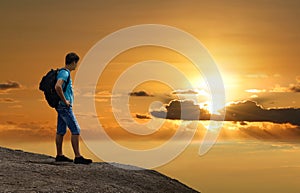 Tourist on mountain of gold sunset.