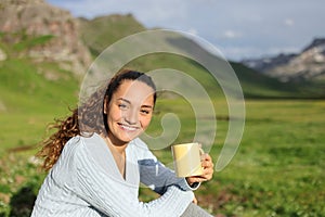 Tourist in a mountain valley looking at you with coffee cup