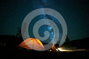 Tourist near his camp tent at night.