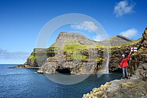 Tourist Near Mulafossur Waterfall in Gasadalur, Faroe Islands