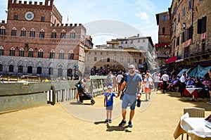 tourist near Palazzo Publico in Piazza del Campo Town hall of Siena, Tuscany, Italy