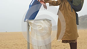 Tourist opens trash can cap and throws unnecessary garbage