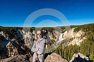 Tourist overlooking waterfall in Yellowstone