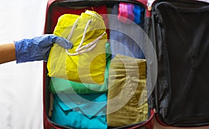 Tourist packing suitcase with gloves.