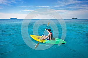 tourist paddling on kayak in tropical sea, beach travel to Thailand