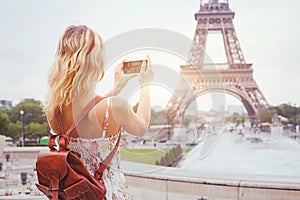 Tourist in Paris visiting landmark Eiffel tower, sightseeing in France, mobile photo on smartphone