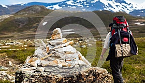 A tourist passing a milestone on a mountain trail