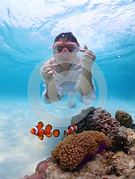 Tourist people diving with snorkel to see nemo fish , beautiful fish and coral at Samaesarn Island of Thailand