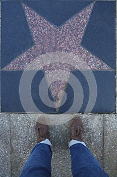 Tourist photographing her with an empty star on the Walk of Fame in Hollywood. Hollywood Walk of Fame features more than 2,500