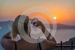 Tourist photographing sunset on Santorini